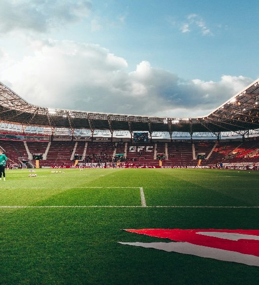 football stadium pitch level view under blue sky