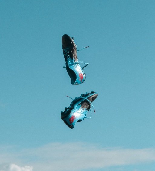 blue football boots in the air