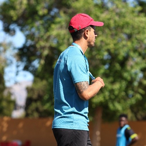 football coach watching tackling drills during academy training