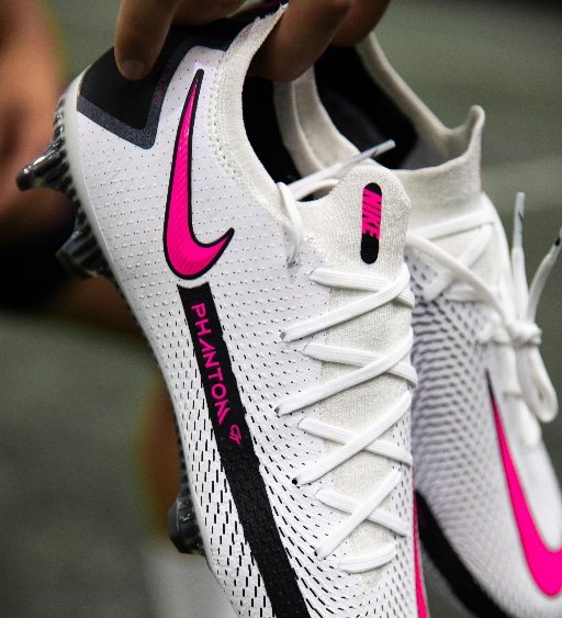 white football boots with studs in hand