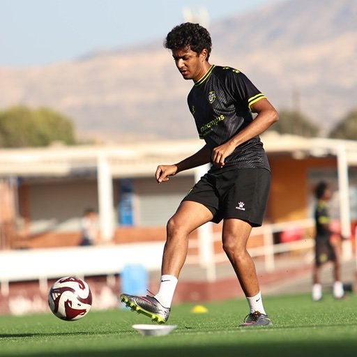 youth football player controlling ball during football tryout